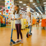 little girlfriends rides on scooters, playground