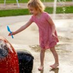 smiling child playing at splash pad playground in 2023 11 27 05 18 05 utc